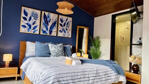 A bedroom with a bed, a nightstand, a lamp, a mirror, and wall art. - 3 Level Luxe Penthouse • 7 Real Beds • Mountain Views & Balcony • Zona T (Bogota)