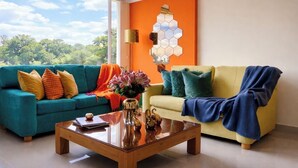 A living room with two sofas, a coffee table, and a wall art piece. - 3 Level Luxe Penthouse • 7 Real Beds • Mountain Views & Balcony • Zona T (Bogota)