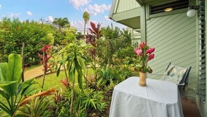 Ein Garten mit verschiedenen Pflanzen und einem Tisch mit Blumen in einer Vase.