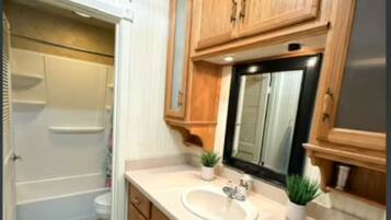 Tina con regadera, secadora de cabello, toallas, jabón