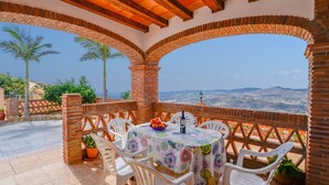 A patio with a table set for two, surrounded by brick arches, overlooking a mountainous landscape. - Villa Biznaga Mijas by Ruralidays (Málaga)