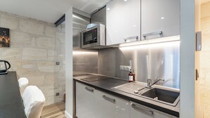 A modern kitchen with stainless steel appliances, a microwave, and a sink. - Superb quality duplex in hypercentre with rooftop and air conditioning (Bordeaux)