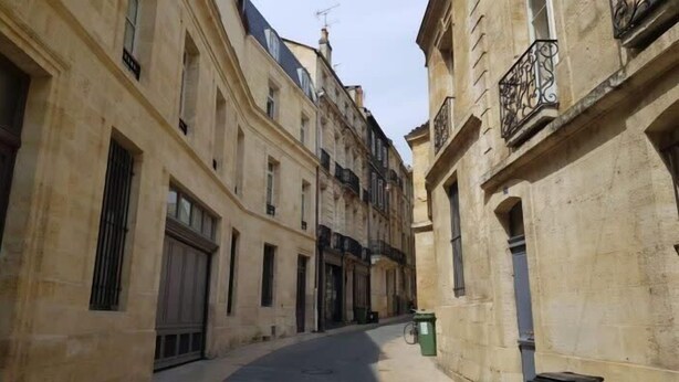 A narrow street between old buildings with large windows and balconies. - Superb quality duplex in hypercentre with rooftop and air conditioning (Bordeaux)