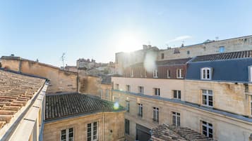 Vista de un callejón estrecho entre edificios con tejados de tejas y fachadas de piedra.