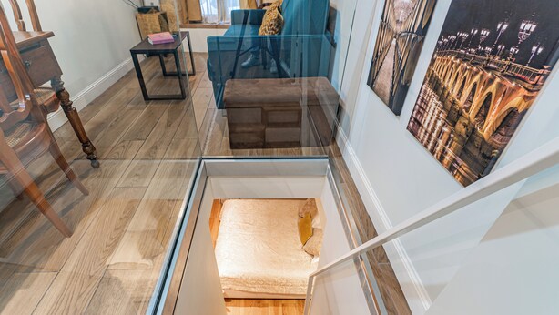 Un intérieur moderne avec un escalier en verre menant à une chambre à coucher.