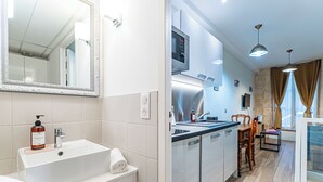 Une salle de bain moderne avec un grand miroir, un lavabo blanc et une serviette.