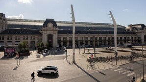 Een treinstation met een groot gebouw, een klokkentoren en een overdekt gebied.