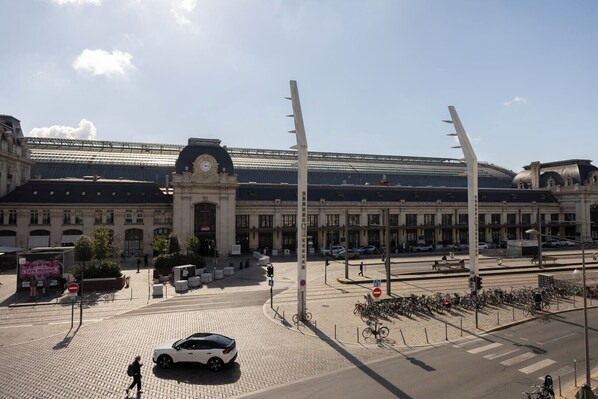 Een treinstation met een groot gebouw, een klokkentoren en een overdekt gebied.