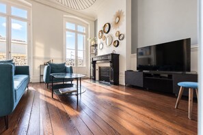 A living room with a fireplace, a television, and a dining area with a glass table.