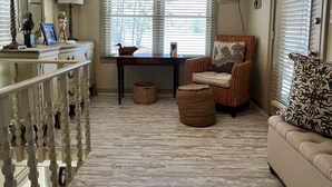 A cozy living room with a wooden floor, a sofa, a chair, a table, and a lamp. - Peaceful vacation very close to The Landing!! (Equality)