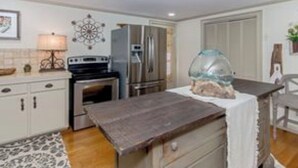 A kitchen with white cabinets, a stove, a refrigerator, and a fish tank on the counter. - Peaceful vacation very close to The Landing!! (Equality)