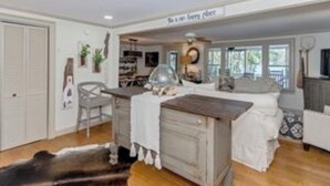 A cozy living room with a fireplace, a dining table, and a sofa. - Peaceful vacation very close to The Landing!! (Equality)