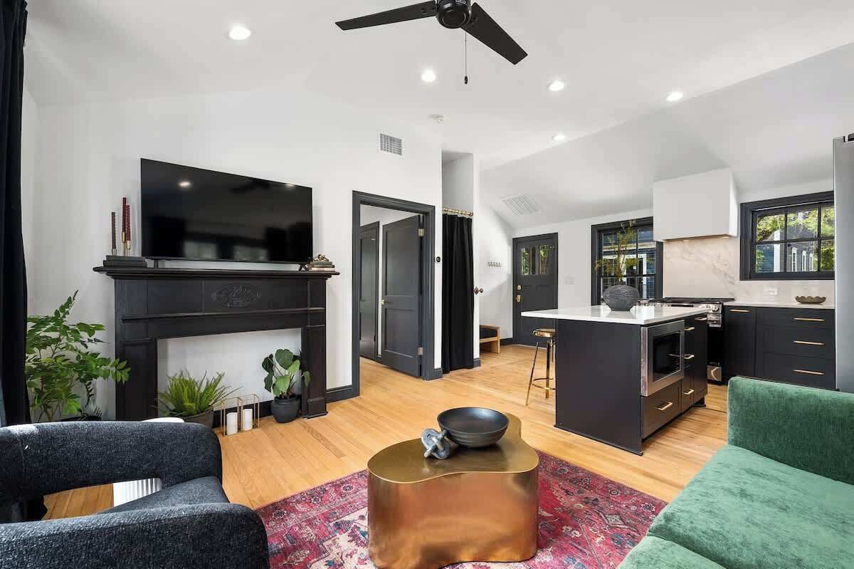 A modern living room with a fireplace, a TV, and a green sofa.
