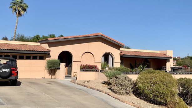 A two-story building with a flat roof, arched doorways, and a garage. - Room with mountain views/hiking, private entrance & peaceful courtyard. (Phoenix)