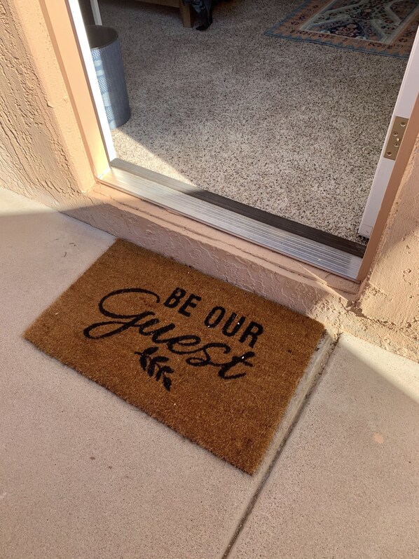A brown doormat with the words "BE OUR GUEST" written on it.