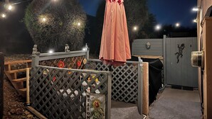A gated outdoor area with a welcome sign, a wooden bench, and string lights. - Room with mountain views/hiking, private entrance & peaceful courtyard. (Phoenix)