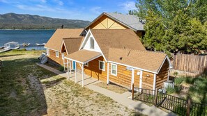 A log cabin with a covered porch, a dock, and a lake view. - Lakefront Oasis - Lakefront, Walk to Village, Deck, Barbecue, Lake View (Big Bear Lake)