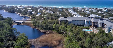Ein Küstenresort mit einem großen Gebäude, das mehrere Balkone, einen Swimmingpool und einen Blick auf den Ozean bietet.