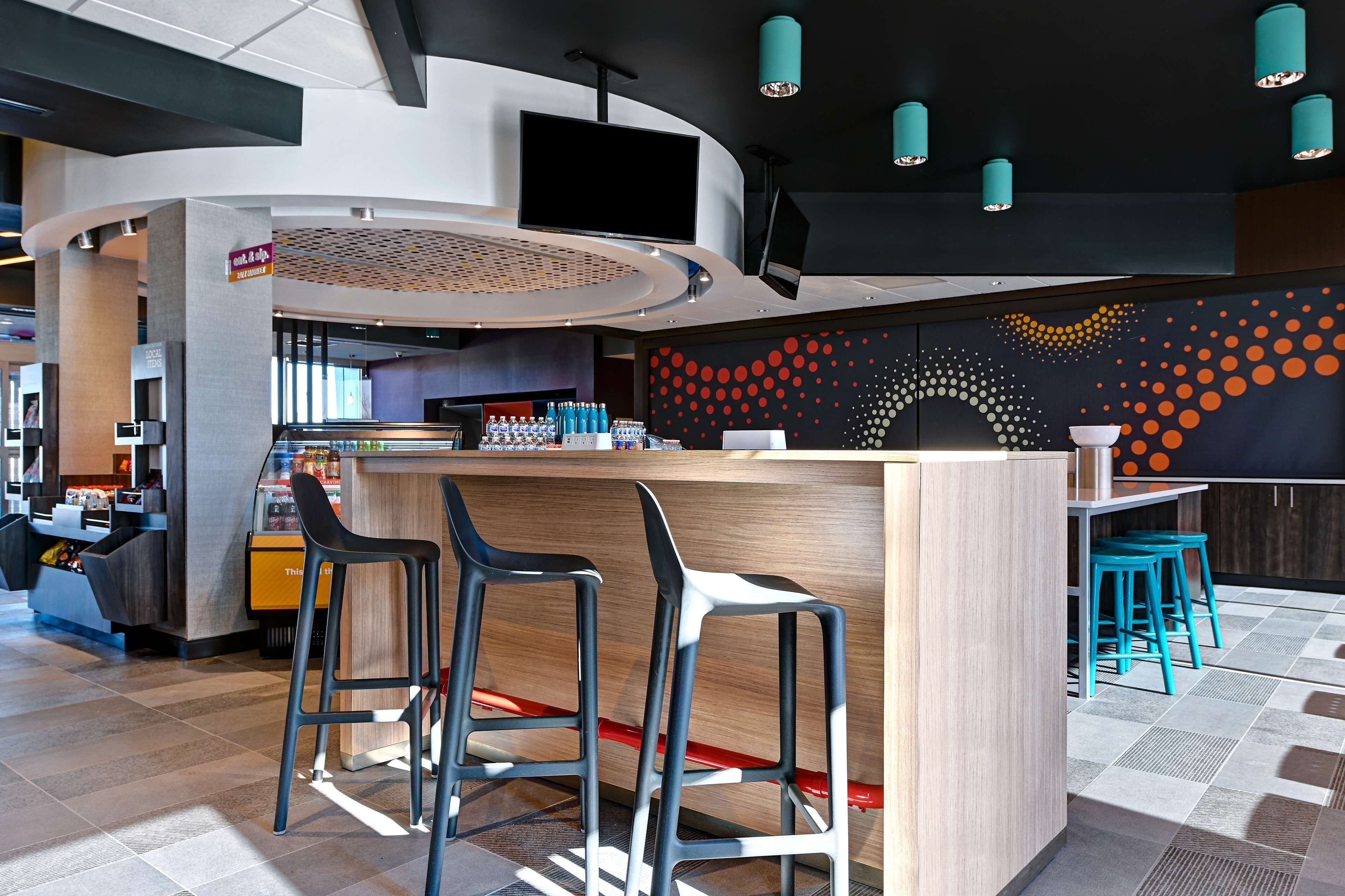 A modern bar area with a counter, bar stools, and a wall with a dotted pattern.