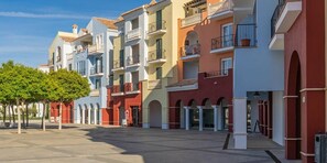 A multi-story residential building with balconies, a central courtyard, and a tree-lined street. - Spectacular and stylish 2 bed apartment - AA1711LT (Torre-Pacheco)