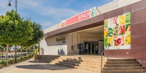 A supermarket with a visible entrance, steps leading up to it, and a large advertisement on the building. - Spectacular and stylish 2 bed apartment - AA1711LT (Torre-Pacheco)
