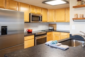 Fully equipped kitchen with oven, microwave, and sink.