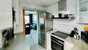 A modern kitchen with stainless steel appliances, a built-in oven, and a black countertop. - NON STRESS Duplex Penthouse with SEA views (Alboraya)