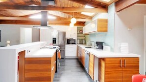 Eine moderne Küche mit Holzschränken, Edelstahlgeräten und einem Oberlicht.