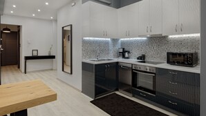 A modern kitchen with a built-in microwave, stove, and dishwasher. - Acropolis Deluxe Apartment (Athens)