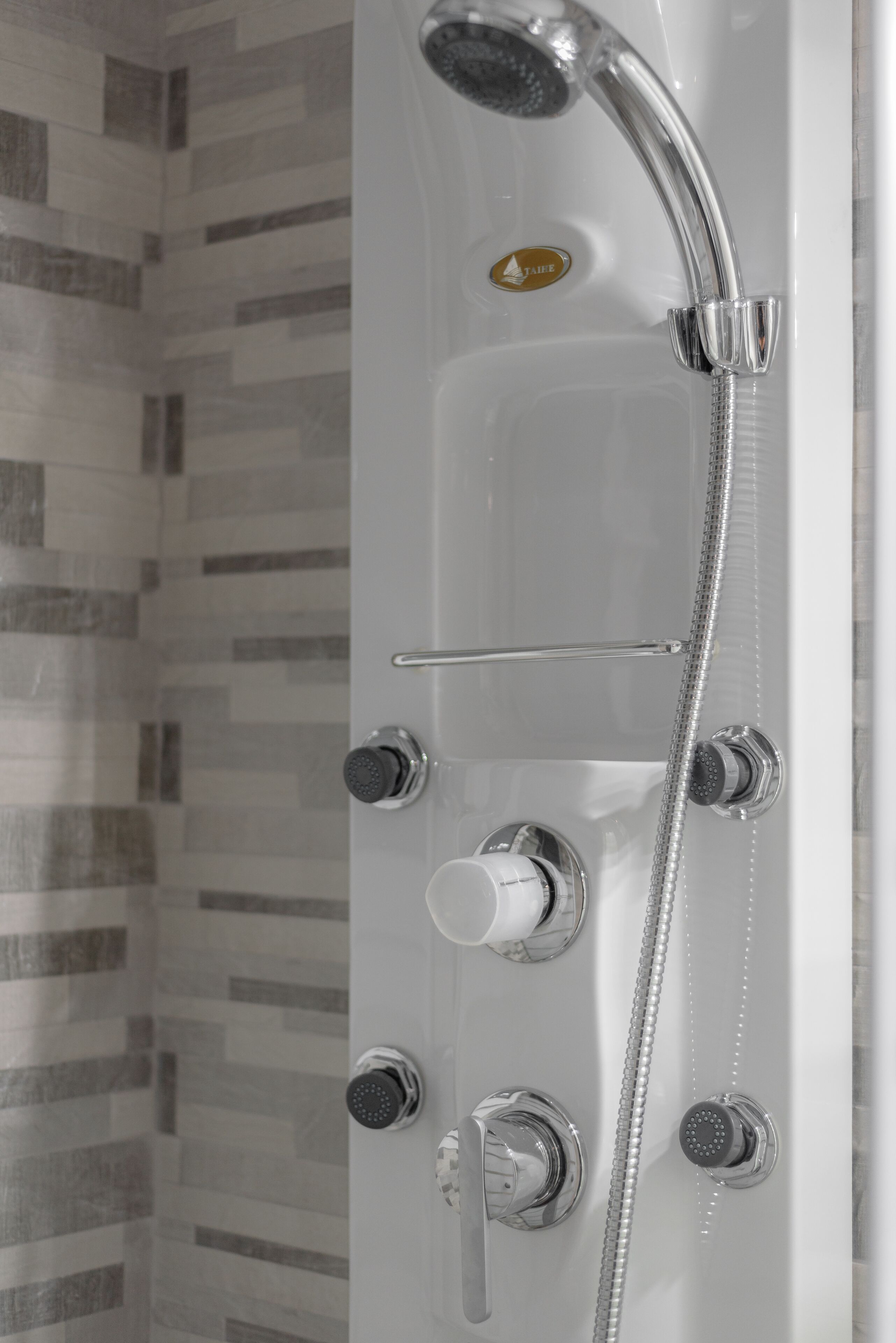 A modern shower with a handheld showerhead, a fixed showerhead, and a rain shower head.