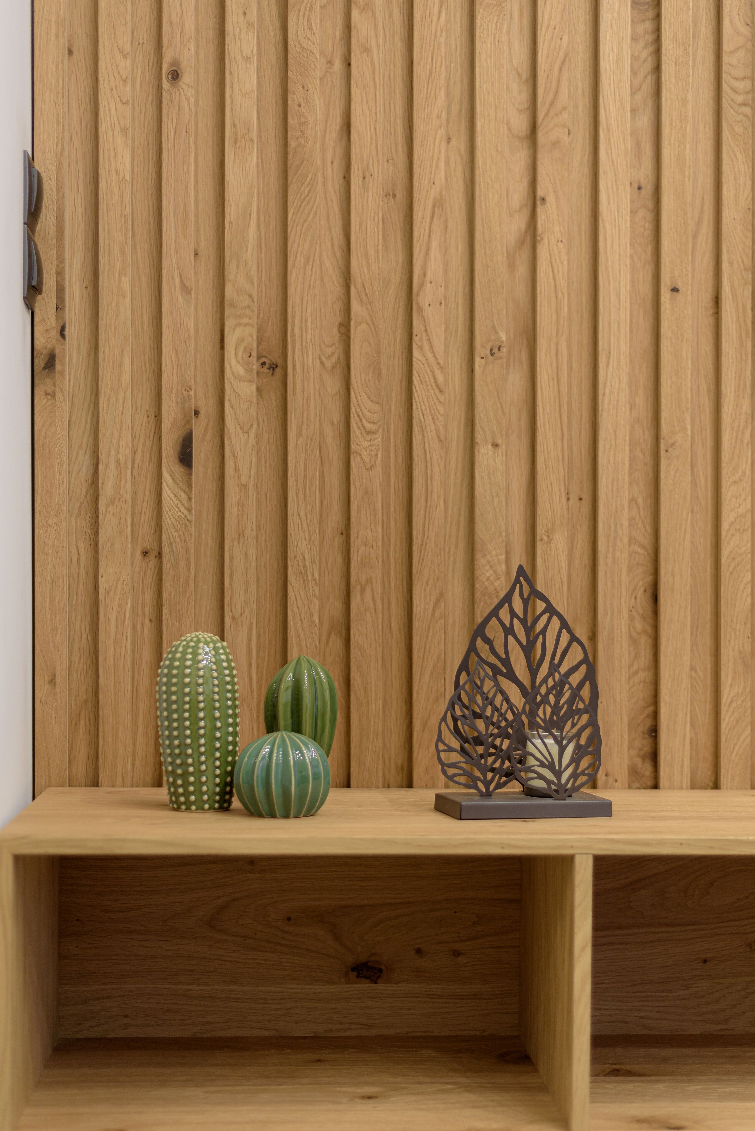 Eine Holzbank mit zwei Pflanzkästen vor einer Holzwand.