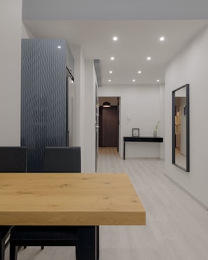 Relax in this stylish room with a dining table, sofa, and large mirror.