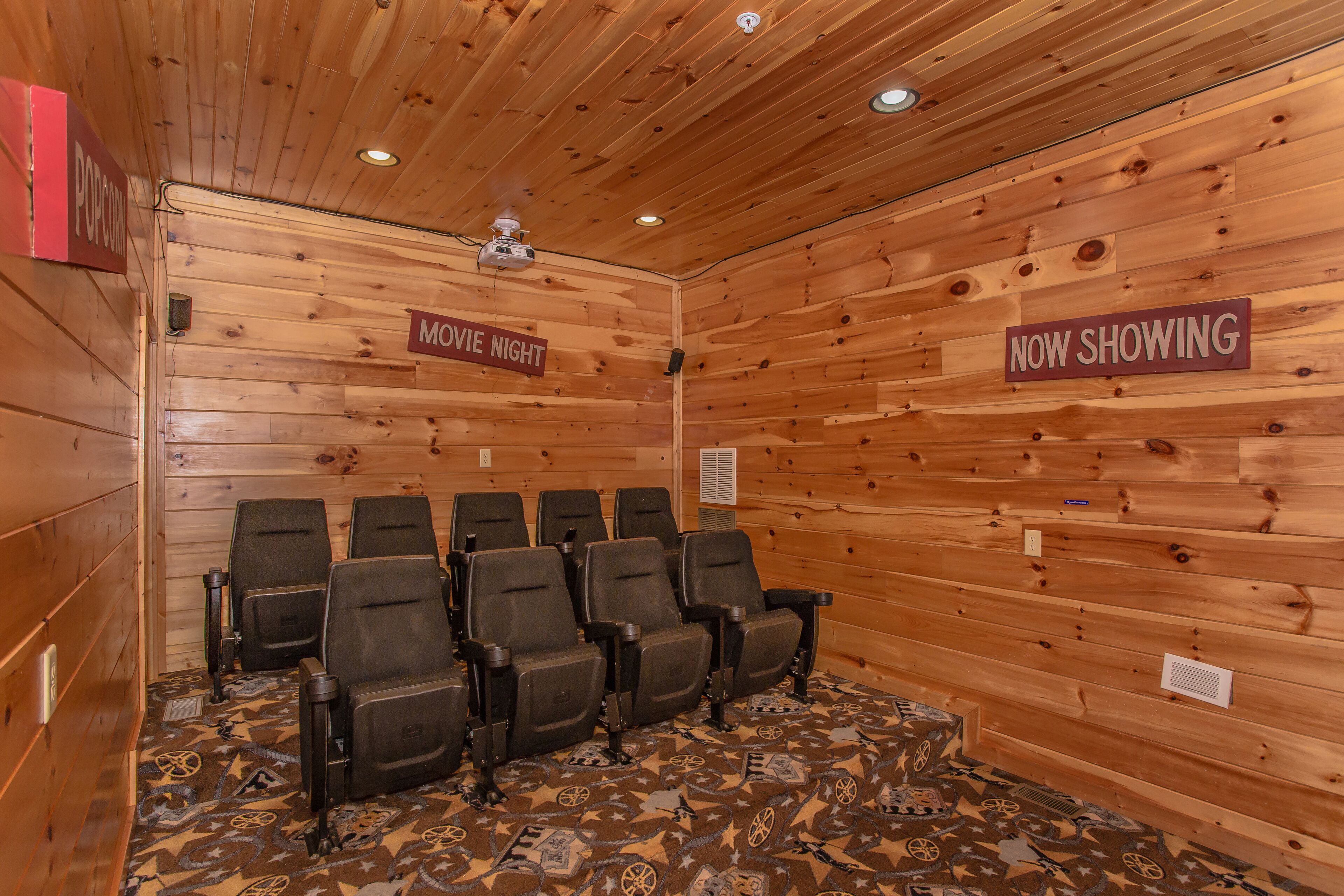 Una habitación con paneles de madera y un cartel que indica 'MOVIE NIGHT' y 'NOW SHOWING'.