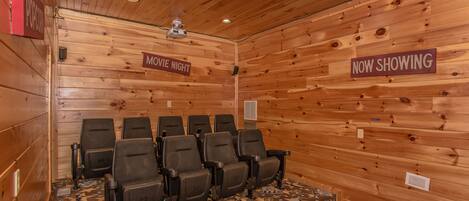 Una habitación con paneles de madera y un cartel que indica 'MOVIE NIGHT' y 'NOW SHOWING'.