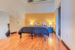 A bedroom with a bed, bedside tables, and a door. - Sosuite | 1BR Penthouse w W/D, Gym, On-Site Bar (Philadelphia)