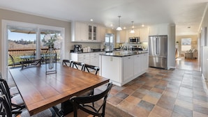 A spacious kitchen with white cabinets, a large island, and stainless steel appliances.