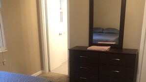 Un dormitorio con cama, cómoda y espejo.