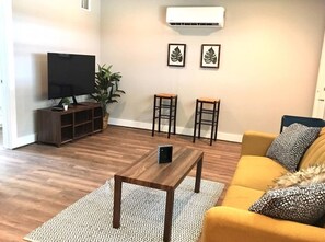 Relax in this stylish living room with a flat-screen TV, coffee table, and comfortable sofa.