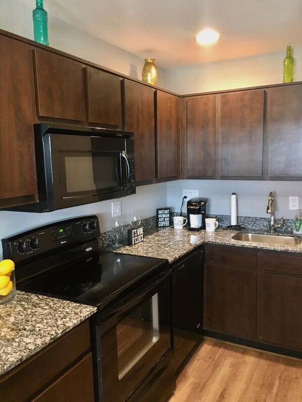 Enjoy cooking in this well-equipped kitchen with a stove, sink, and two coffee makers.