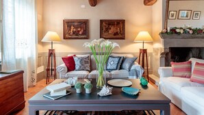 A living room with a sofa set, two lamps, a fireplace, and a coffee table with decorative items. - Villa BRUNETTA, Discover your Modern but Traditional Villa in Lucca (Capannori)