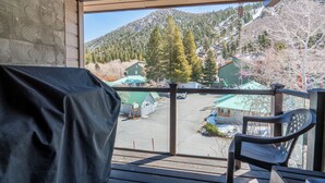A balcony with a view of a mountain, a covered barbecue area, and a chair. - Edgewater #20 - 2 BD/2 BTH (June Lake)