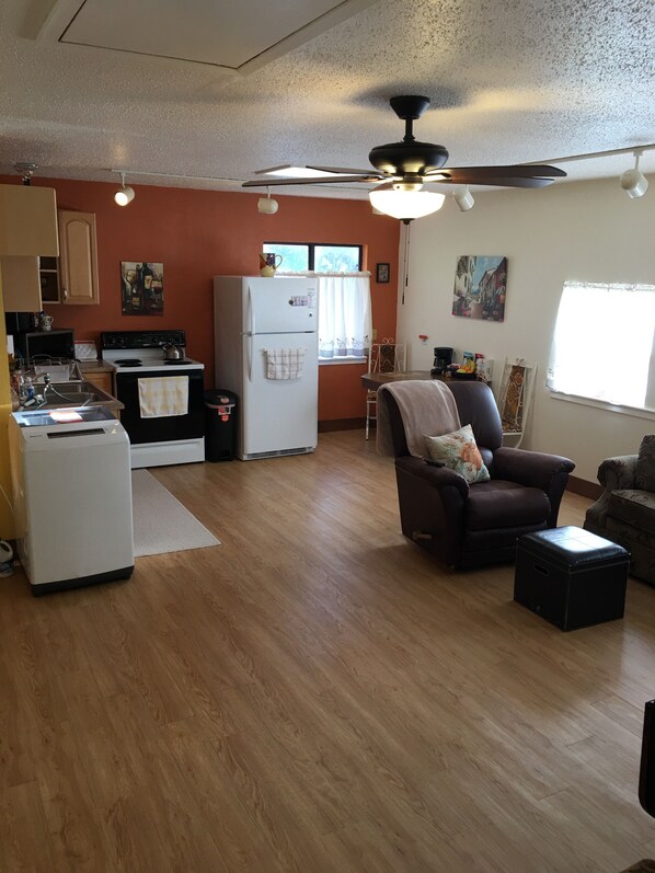 A compact living space with a kitchenette, a ceiling fan, and a dining area.