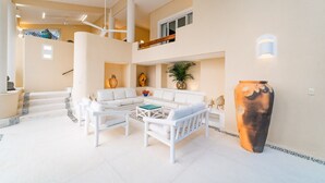 A spacious living area with a white sofa set, a coffee table, and a large vase. - Gated Ocean View Villa with Direct Beach Access (Huatulco)