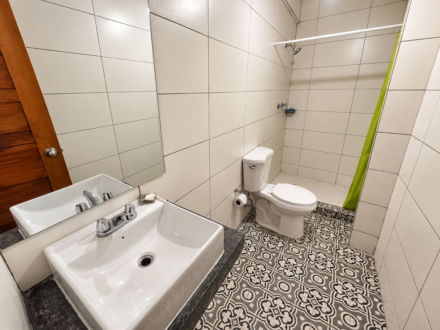 A bathroom with a white sink, toilet, and shower.