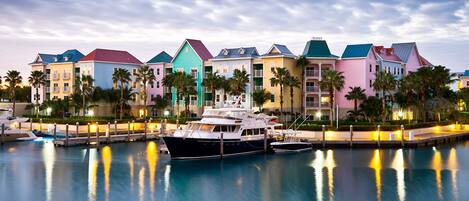 Un puerto deportivo con edificios de colores y un yate amarrado.