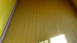 A room with yellow walls and wooden flooring.