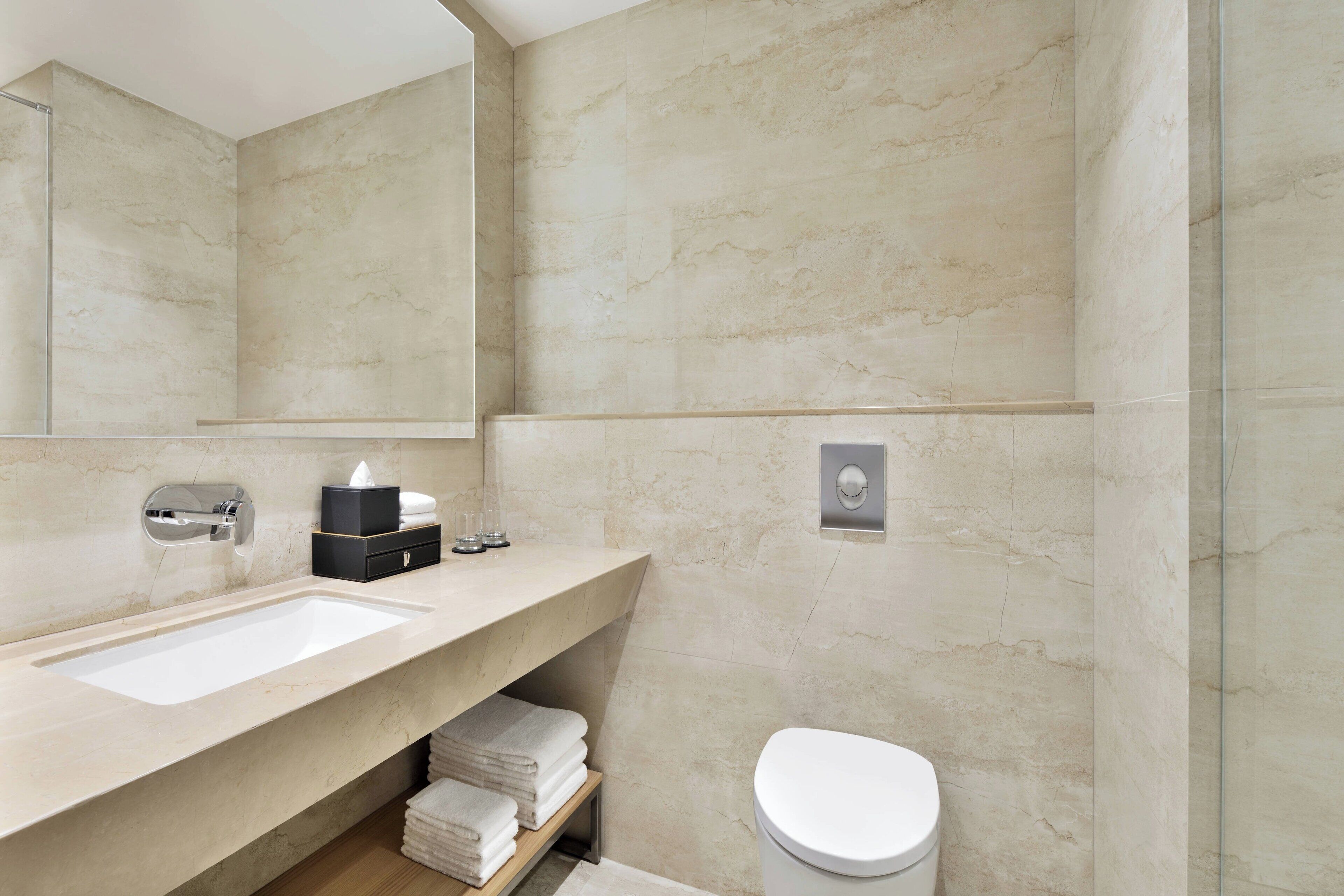 Une salle de bain moderne avec un grand lavabo, des toilettes et un miroir.