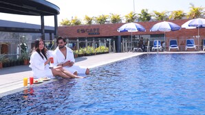 Un área junto a la piscina con un bar llamado 'Escape Lounge' y varias sombrillas.