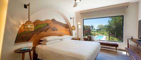 A bedroom with a large bed, a ceiling fan, a view of a swimming pool, and a wooden headboard.