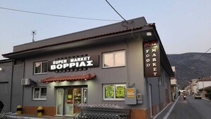 A Super Market Boppiae building with a tiled roof and a sign indicating a market. -  Cute & luxury suite with patio, just few steps away from beach , nearby Delphi (ΙΤΕΑ- ΚΙΡΡΑ)